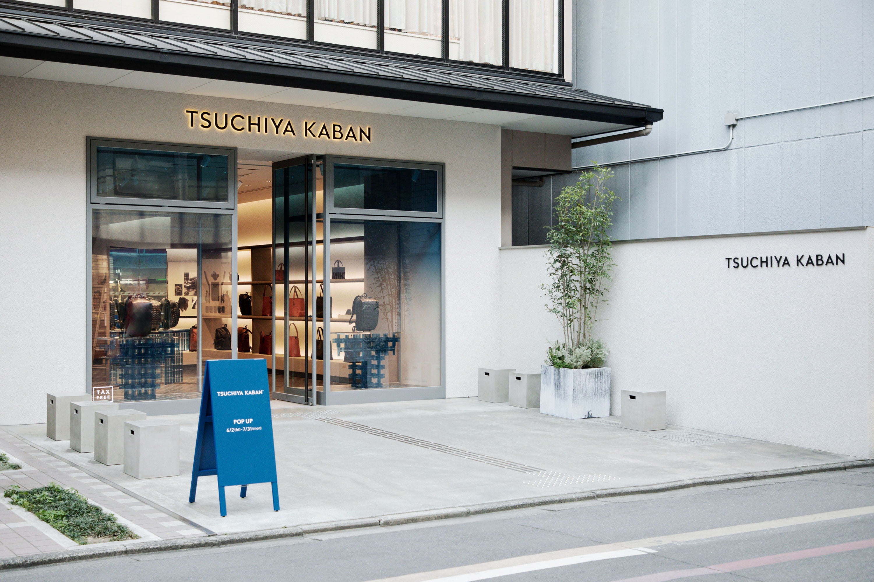 Storefront with glass entrance and blue sign outside.